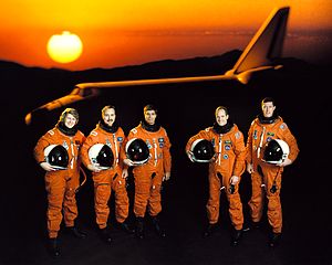 Atlantis shuttle astronauts at sunset holding helmets