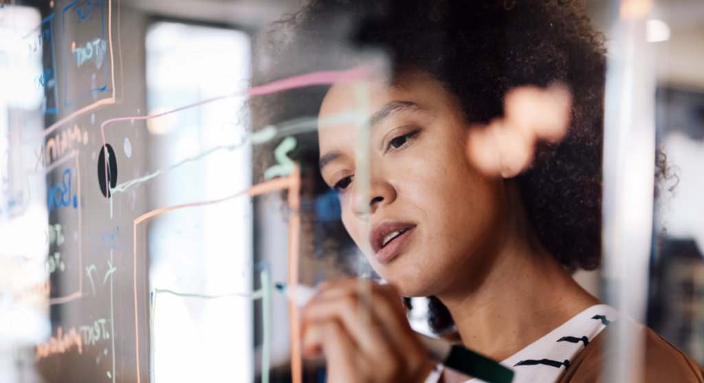 woman maps customer journey with markers on glass